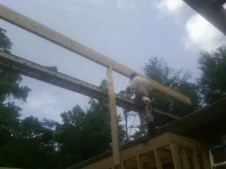 Carpenter setting a ridge beam over a new addition frame — Ice Dam Removal by Roofing Brothers in Arendtsville
