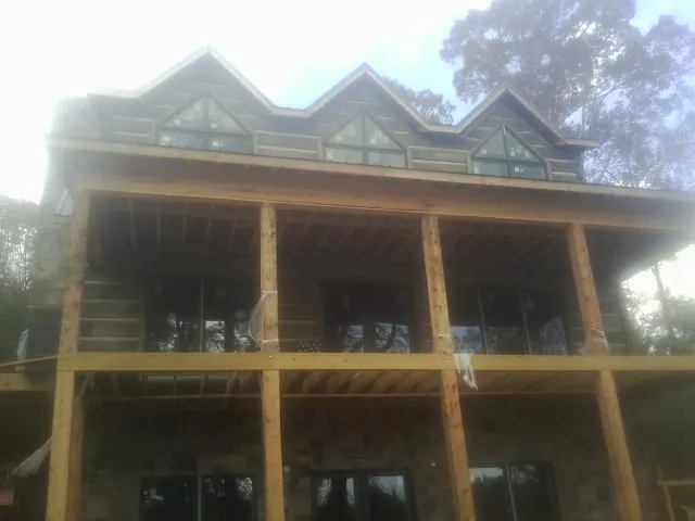 Dormers and porch framing on a large log home under construction — Roof Coating work by our crew in Arendtsville