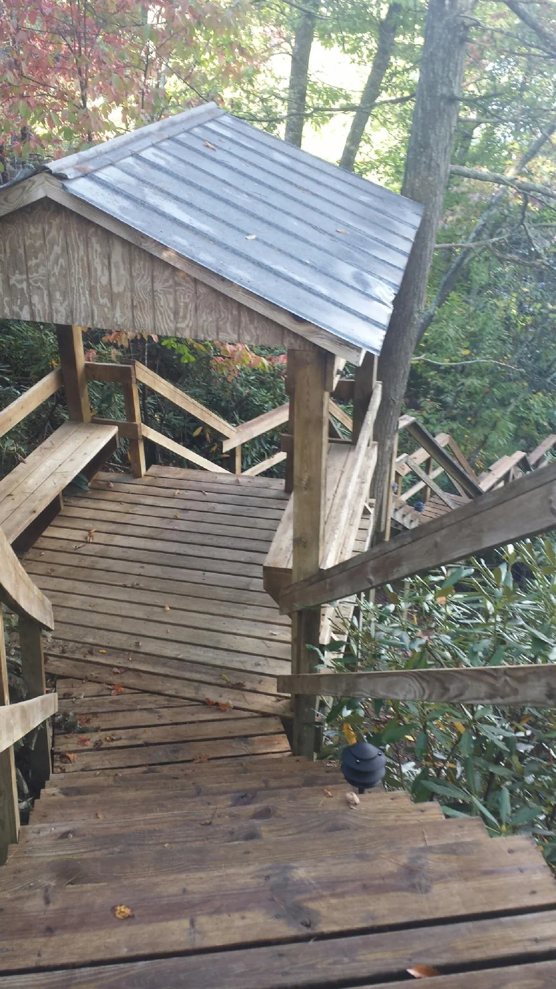 Metal roofed shelter over wooden steps on a wooded walkway — Skylight Repair & Installation work by our crew in Arendtsville